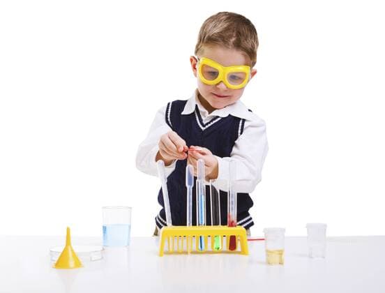 kleiner Forscher experimentiert in einem Labor Early education. Young boy performing chemistry experiments BLWS237753
