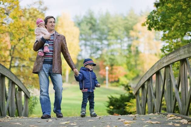 junger Vater mit seinen beiden Kindern im Park an einem Herbsttag Young father with two kids enjoying beautiful autumn day BLWS237844