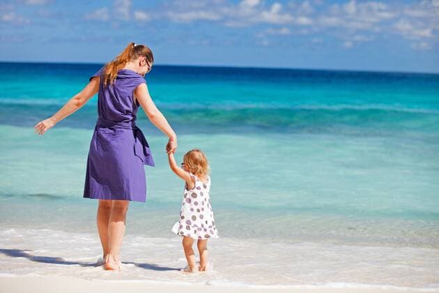 eine junge Mutter steht mit ihrer kleinen Tochter am Strand a young mother standing with her little daughter on the beach BLWS270798