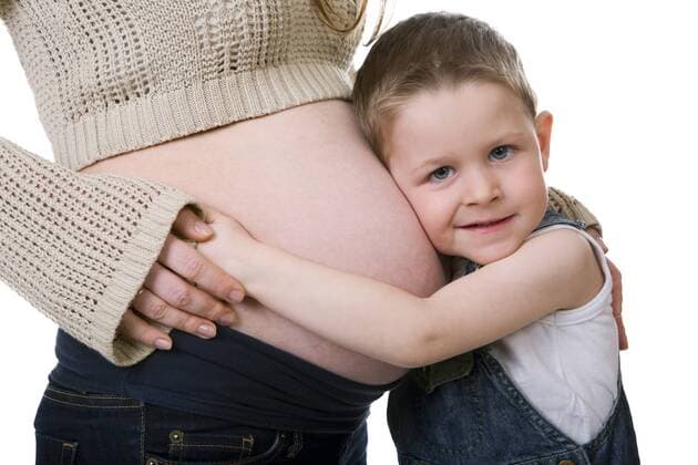 kleiner junge umarmt den dicken Bauch seiner schwangeren Mutter Little brother. Cute small boy talking with his pregnant mother BLWS237832