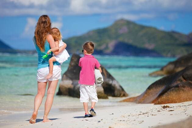 junge Mutter geht mit ihren zwei kleinen Kindern am tropischen Strand spazieren a young mother walking with her two little children on sandy beach BLWS270927
