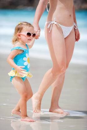 kleines Maedchen geht an der Hand ihrer Mutter am Sandstrand spazieren little girl walking with her mother on sandy beach BLWS270940