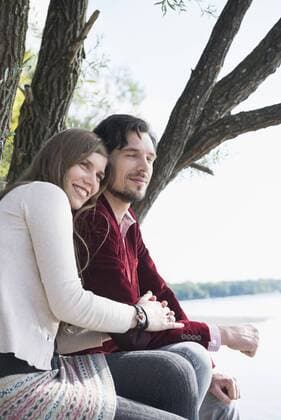 Happy young couple sitting lake mit_2002_06220
