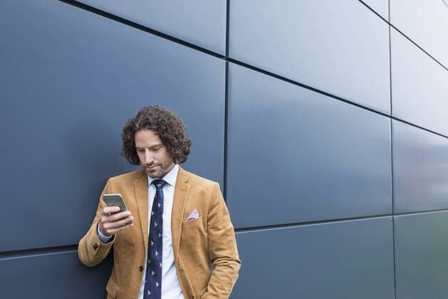 Man business suit cell phone reading SMS mit_2002_06283