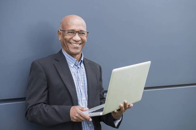 Happy African businessman holding laptop computer mit_2002_06310