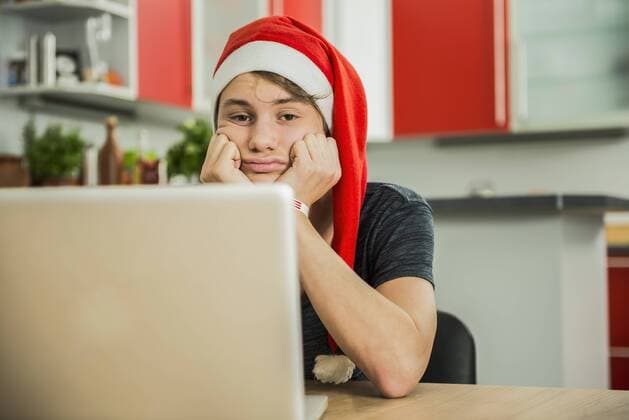 Bored young man with Santa hat using laptop, Munich, Bavaria, Germany mit_2002_06679