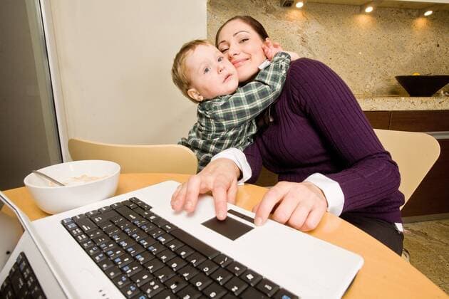Woman looking after her child while working at home.  1313453