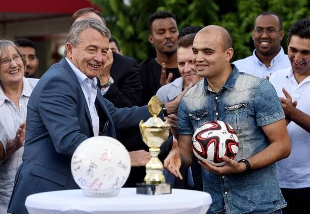 09.09.2015, xfux, Fussball Testspiel, SG Egelsbach Refugees United vs. DFB-Betriebsmannschaft, emspor v.l. DFB Praesident Wolfgang Niersbach (Deutscher Fussball Bund) uebergitb einen Ball mit Unterschriften an Kapitaen Faward Ansari (SG Egelsbach Refugees United) Fussball Testspiel, SG Egelsbach Refugees United vs. DFB-Betriebsmannschaft