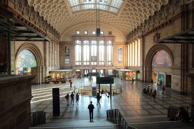 Fahrgäste und Passanten flanieren durch den sanierten Leipziger Hauptbahnhof und der mit Sonnenstrahlen durchfluteten Westhalle, Leipzig, Deutschland