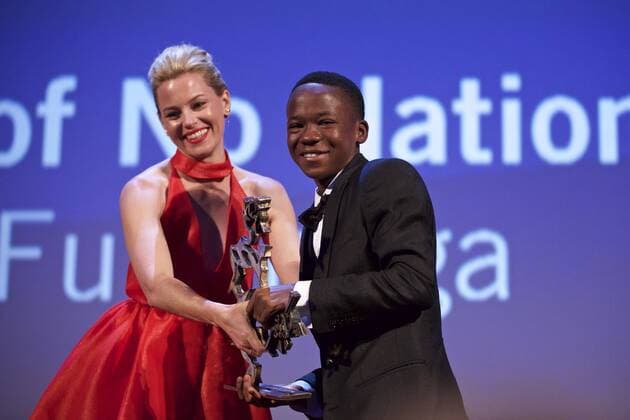 (150912) -- VENICE, Sept. 12, 2015 -- Actor Abraham Attah (R) receives the Marcello Mastroianni Award to a Young Actor from a jury member Elizabeth Banks, for his role in Beasts of No Nations , during the award ceremony at the 72nd Venice Film Festival, at the Lido of Venice, Italy, Sept. 12, 2015. ) ITALY-VENICE-FILM-FESTIVAL-72ND-AWARD JinxYu 