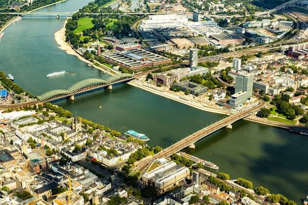 Rhein bei Köln Der Fluss Rhein, mit der Hohenzollernbrücke (Hintergrund) und der Deutzer Brücke bei Köln aus der Luft. Auf der rechten Rheinseite ist das Messegelände in Deutz zu erkennen.