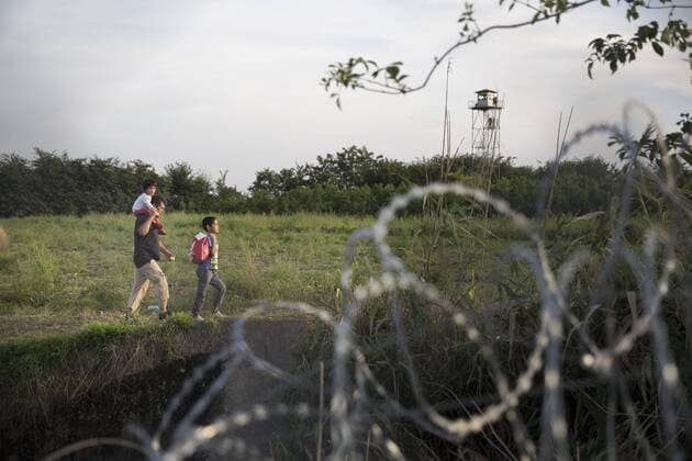 Sept. 14, 2015 - Roszke - RoszRoszke, Hungary- September 14, 2015-- Immigrants walking behind a barbed wire fence as Hungary began closing it s southern border on Monday They were funneled towards a formal checkpoint where numerous people were detained and put on buses at the Roszke border crossing. Roszke  - ZUMAn230