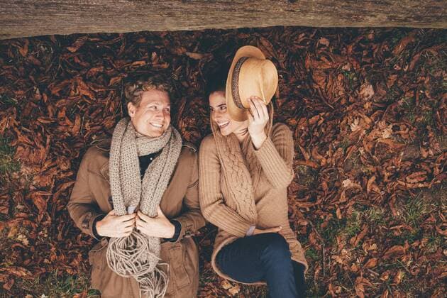 Young couple lying side by side on autumn leaves in an park model released Symbolfoto  CHAF000216