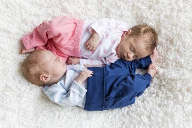 Newborn twins sleeping on white blanket model released Symbolfoto  SHKF000332
