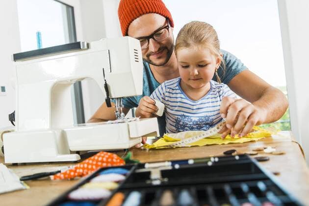 Father and daughter at home using sewing machine model released Symbolfoto property released  UUF005133