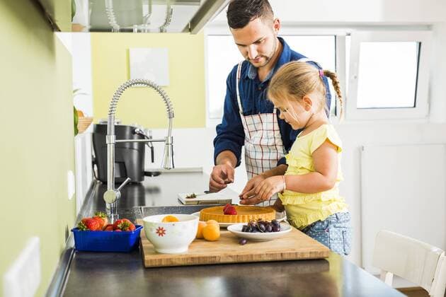 Father and daughter in kitchen preparing fruit cake model released Symbolfoto property released  UUF005181