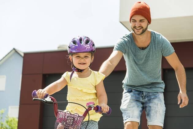 Father supporting daughter on bike model released Symbolfoto  UUF005195