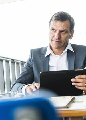 Businessman sitting outdoors, using digital tablet model released Symbolfoto  UUF005212