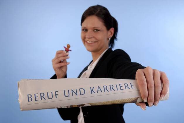 laechelnde junge Frau mit Babyschnuller in der einen und Zeitschrift Beruf und Karriere in der anderen Hand smiling young woman with comforter in one and magazine job and career in the other hand BLWS242936