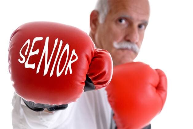 Rentner mit Boxhandschuhe mit der Aufschrift Senior pensioner with boxing gloves BLWS243135