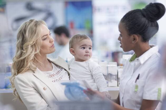 Pharmacist assisting client with baby in drugstore model released Symbolfoto property released  ZEF005896