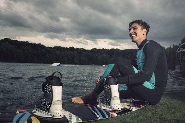 Relaxed young wakeboarder sitting at lakeshore model released Symbolfoto property released  MADF000492