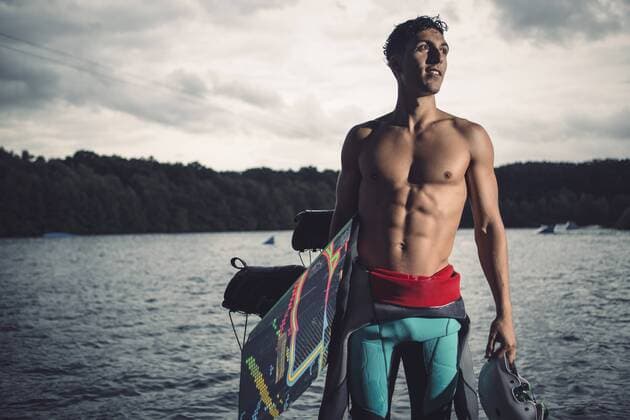 Young wakeboarder standing with his equipment at lakeshore model released Symbolfoto property released  MADF000504