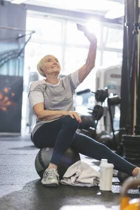 Senior woman in gym taking a selfie model released Symbolfoto property released  MADF000509