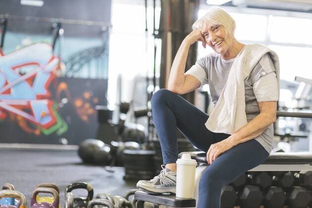Smiling senior woman in gym having a break model released Symbolfoto property released  MADF000516