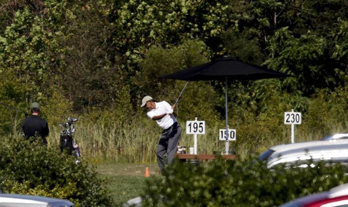 US President Barack Obama stretches before playing golf at Renditions Golf Club in Davidsonville, Md, on September 19, 2015. Pool photo by Aude Guerrucci  WAX20150919902