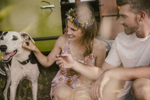 Couple playing with a dog in front of van model released Symbolfoto property released  MFF002069