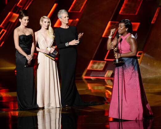 Actress Uzo Aduba (R) accepts the award for Outstanding Supporting Actress in a Drama Series for Orange Is the New Black from actresses Emma Roberts (L) and Jamie Lee Curtis (C) onstage during the 67th Primetime Emmy Awards in the Microsoft Theater in Los Angeles on September 20, 2015.  LAP20150920835 KENxMATSUI