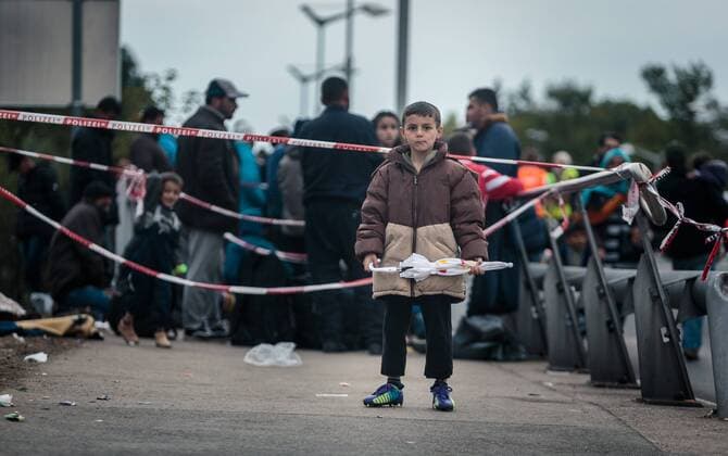 Salzburg 25.09.2015, Grenzuebergang, Salzburg, AUT, Fluechtlingskrise in der EU, im Bild Fluechtlinge an der Grenze zu Deutschland, ein Kind wartet mit einem Regenschirm in der Hand Migrants on the German Border, a child is waiting with an umbrella in his hand. Thousands of refugees fleeing violence and persecution in their own countries continue to make their way toward the EU, border crossing, Salzburg, Austria on 2015 09 25.  EX_JFK 