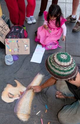 IMAGO Creative: NGO, Kunst im öffentlichen Raum und Kulturinitiativen Child and artist drawing on sidewalk in street in downtown Lima Peru at San Martin Square McPBBA McPBBA