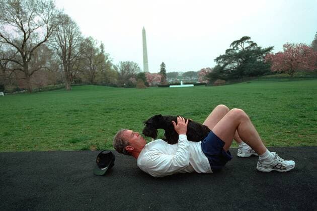 April 10, 2001 - Washington, DC, United States of America - U.S. President George W. Bush lays down on the jogging track to play with his dog Barney after going for a run on the South Lawn of the White House April 10, 2001 in Washington, DC. Washington United States of America - ZUMAp138