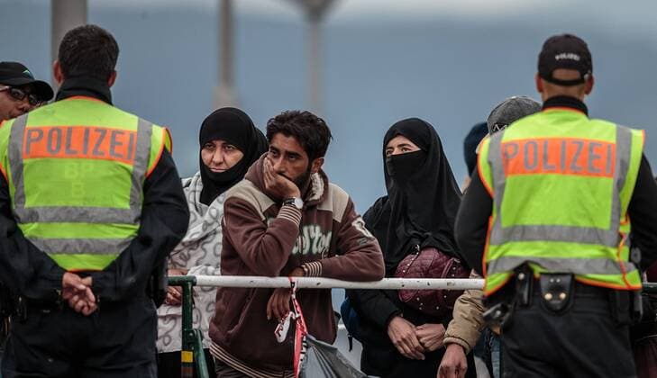 Freilassing 25.09.2015, Grenzübergang, Freilassing, AUT, Fluechtlingskrise in der EU, im Bild Flüchtlinge an der Grenze zu Oesterreich, Polizisten bewachen die Grenze Poliveman watch to Migrants on the Austrian Border. Thousands of refugees fleeing violence and persecution in their own countries continue to make their way toward the EU, border crossing, Freilassing, Germany on 2015 09 25.  EP_fei 