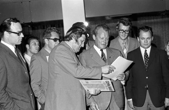 Bundeskanzler Willy Brandt und der Oberbürgermeister von München, Hans Jochen Vogel, besichtigen das Olympische Dorf zu den Spielen 1972 und bekommen die Olympia Parade Schallplatte vorgestellt, Deutschland 1970er Jahre. Chancellor Willy Brandt and the mayor of Munich, Hans Jochen Vogel, visiting the Olympic village at Munich 1972 and get introduced to the Olympiad s vinyl record, Germany 1970s. Copyright: Roba SiegfriedxPilz UnitedArchives03221