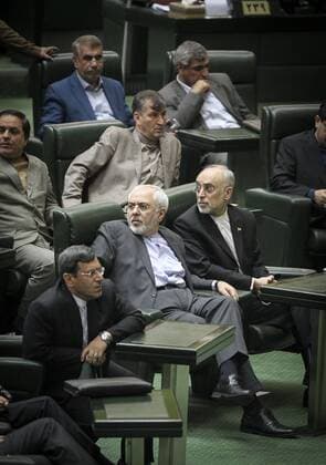 (151011) -- TEHRAN, Oct. 11, 2015 -- Iranian Foreign Minister Mohammad-Javad Zarif (C) and Head of Atomic Energy Organization of Iran (AEOI), Ali-Akbar Salehi (R) react at Iran s Majlis in Tehran, Iran, on Oct. 11, 2015. Iranian parliament approved the general outlines of a plan on Sunday, which obliges the President Hassan Rouhani s administration to take proportional measures in implementing the nuclear deal reached between Iran and the world powers in July 2015. ) IRAN-TEHRAN-NUCLEAR-PARLIAMNET AhmadxHalabisaz 