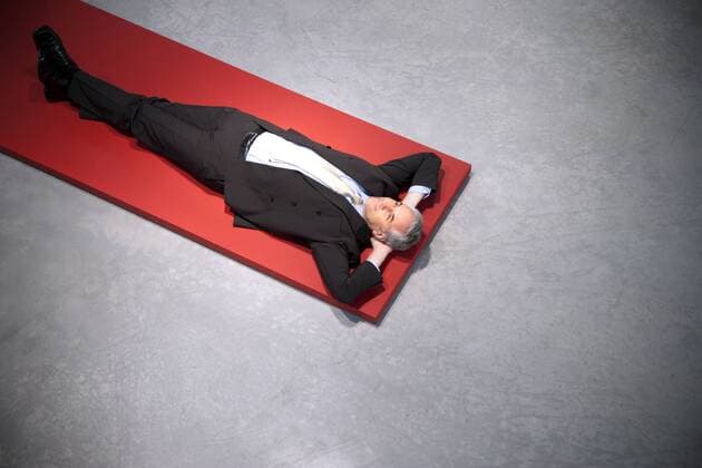 Relaxed businessman lying on floor model released Symbolfoto property released  TOYF001154