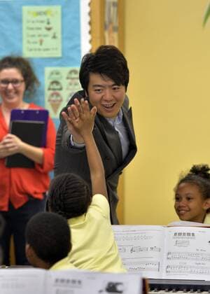 (151022) -- NEW YORK, Oct. 15, 2015 -- Pianist Lang Lang high fives with a boy at a music class at the Roberto Clemente Public School 13 in Brooklyn, New York City, Oct. 22, 2015. Lang Lang cut the ribbon on Thursday to unveil Key Of Inspiration, a three-year public school partnership program with the Lang Lang International Music Foundation that is to offer music educations to second to fifth graders from low-income families at public schools. ) U.S.-NEW YORK-MUSIC-EDUCATION-LANG LANG WangxLei 