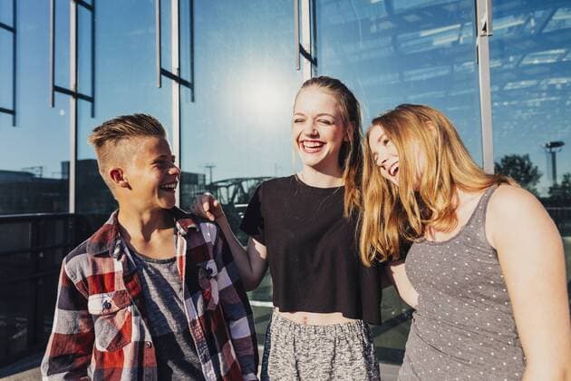 Three laughing teenagers outdoors model released Symbolfoto  AIF000022