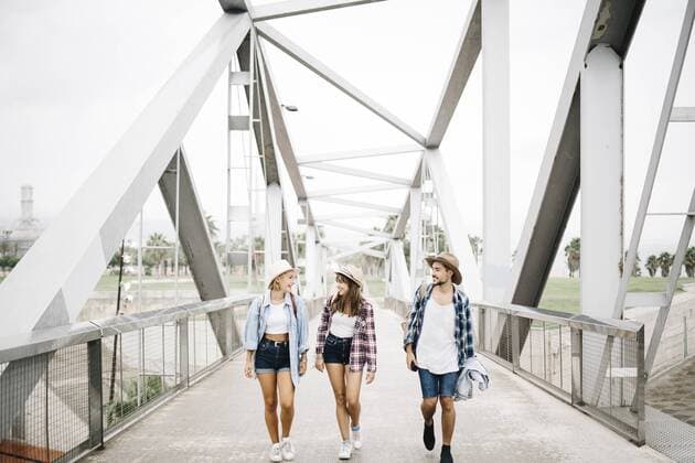 Spain, Barcelona, three happy friends walking side by side on a bridge model released Symbolfoto  JRFF000069