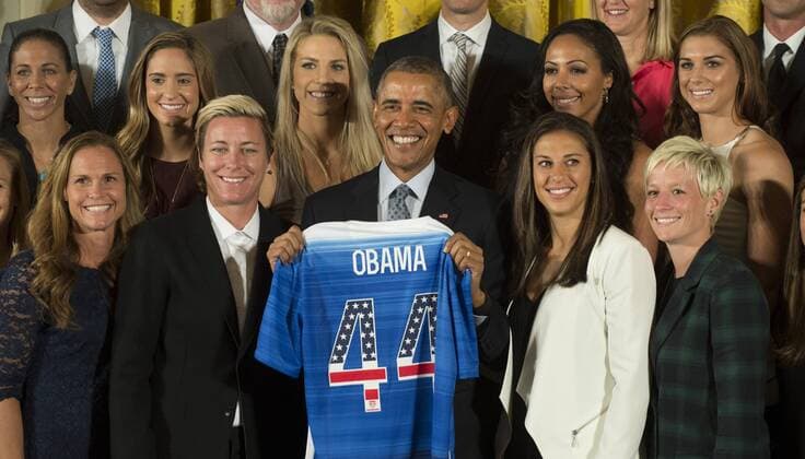U.S. President Barack Obama stands next to Carli Lloyd (R) and Abby Wambach (L) as he holds a team jersey while honoring the U.S. Women s 2015 World Cup champion team at an event in the East Room of the White House in Washington DC on October 27, 2015. Obama said they inspired millions of girls to dream bigger .  WAP2015102704 PATxBENIC
