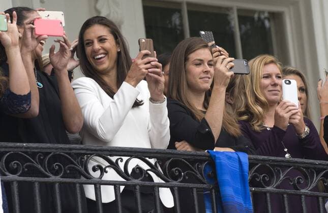Carli Lloyd (white jacket) and other members of the U.S. Women s 2015 World Cup champion team takes photos from a White House balcony of the departure of President Barack Obama aboard Marine One on the South Lawn of the White house in Washington, DC on October 27, 2015. Obama had earlier honored the team at a East Room ceremony. Lloyd scored three goals in the championship game.  WAP2015102710 PATxBENIC