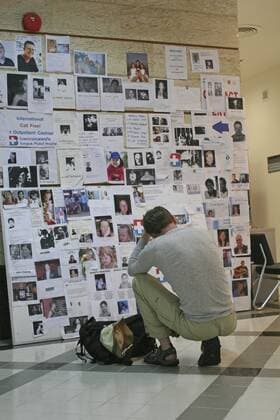 thailand, phang nga district, phuket, tsunami. a french tourist grieves while looking at pictures of french people missing along with hundereds of others posted up at the bangkok phuket hospital, on the 5th jan. Copyright: 904_05_20095003