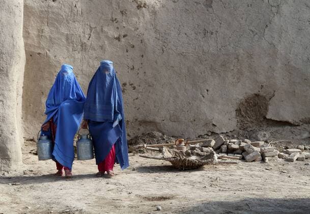 Oct. 22, 2012 - Jebul Saraj, Afghanistan - Afghan women wearing traditional full body covering called Burqa carry milk pails from a USAID milk processing October 22, 2012 in Jebul Saraj, Afghanistan Jebul Saraj Afghanistan - ZUMAp138