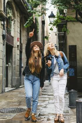 Spain, Barcelona, two young women walking in the city looking up  EBSF000945