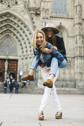 Spain, Barcelona, happy young woman carrying friend piggyback in the city  EBSF000955