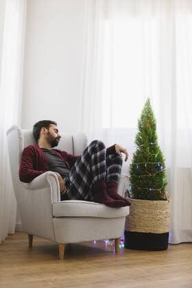 Man sleeping on armchair at home at Christmas time  EBSF001027