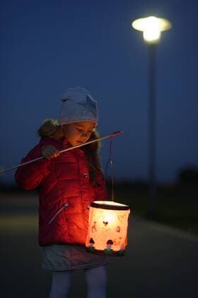 Portrait of little girl with lighted paper lantern on St. Martin s Day at twilight  LBF001248